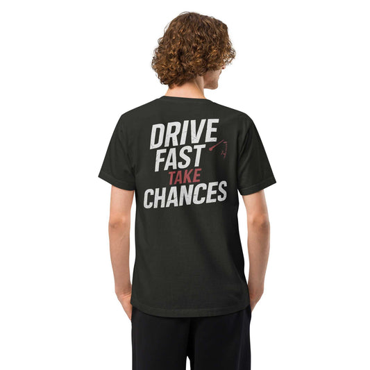 Black oversized tee with "Drive Fast Take Chances" bold white and red typography and tachometer graphic on back, made of vintage-washed 100% cotton.