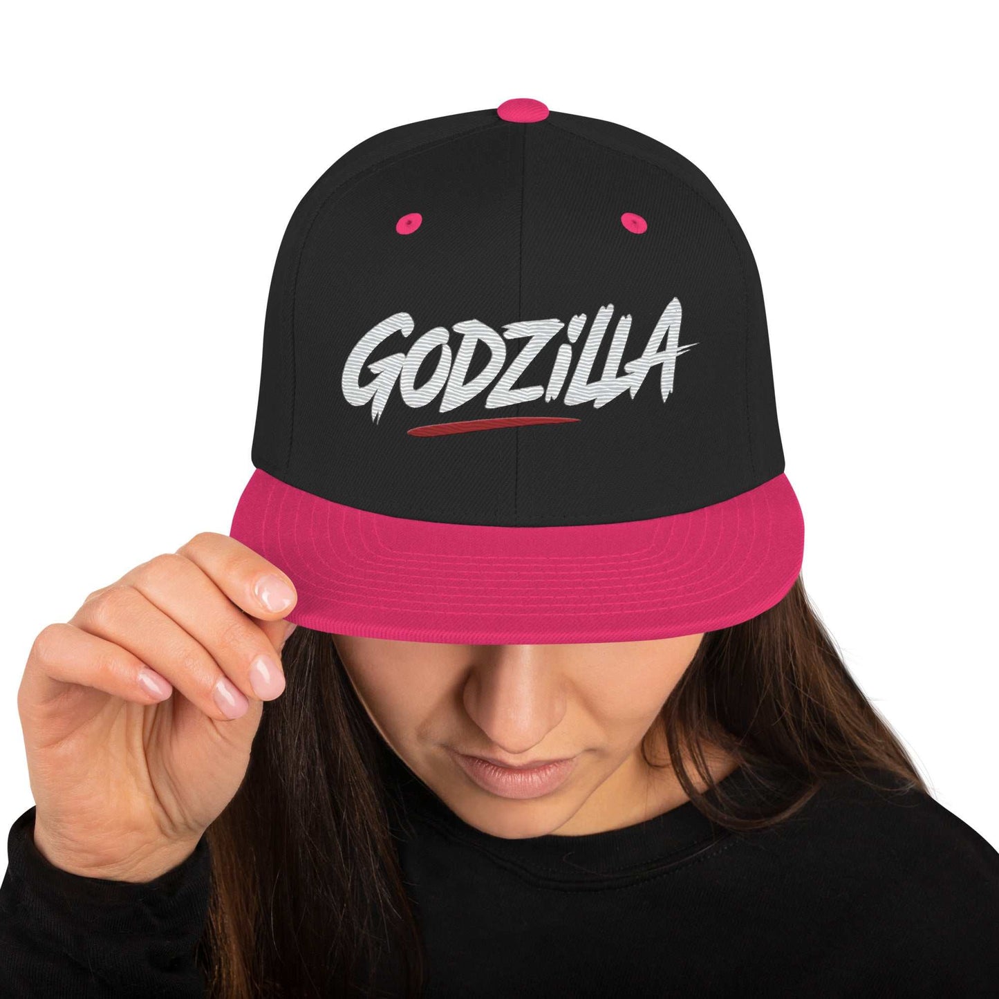Black and pink Godzilla Flat Brim Hat with embroidered logo worn by woman adjusting brim