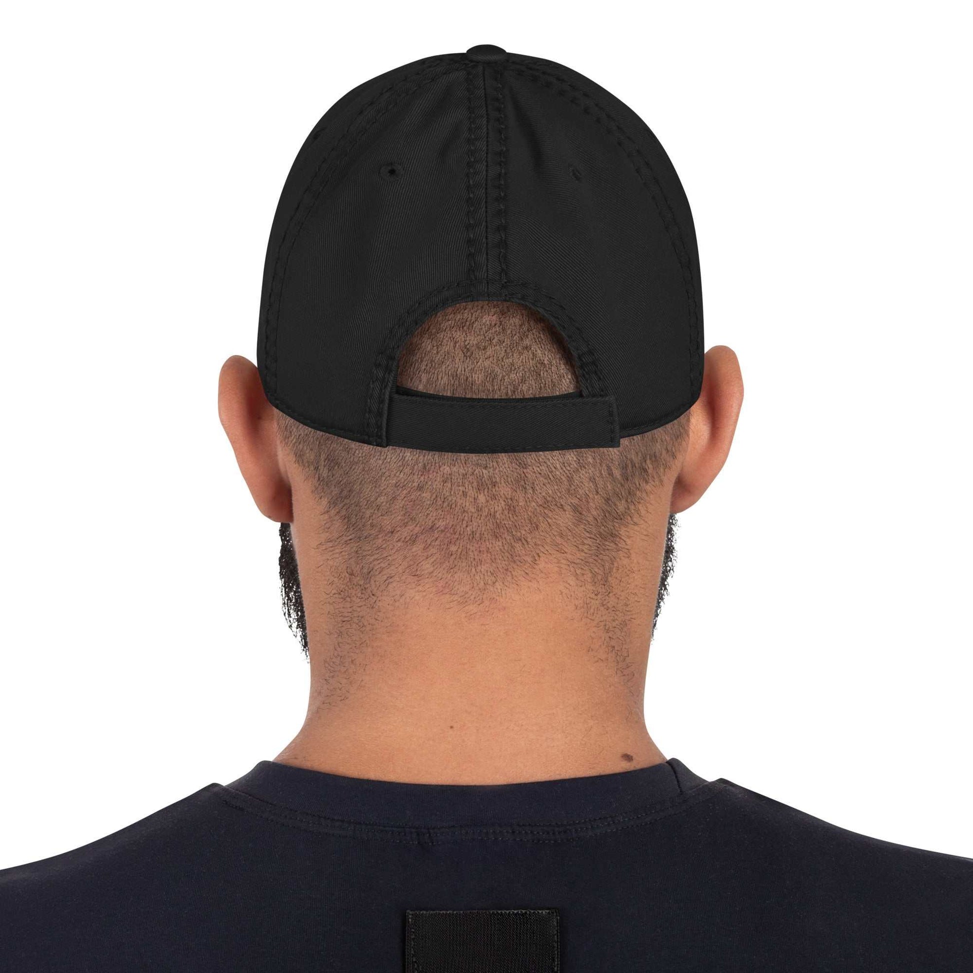 Back view of a man wearing a black DownForce Apparel distressed dad hat with adjustable hook and loop closure.